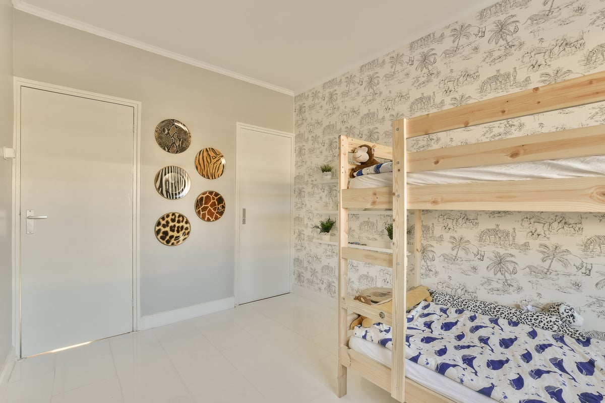 a bedroom with bunk beds and a wall with wallpaper