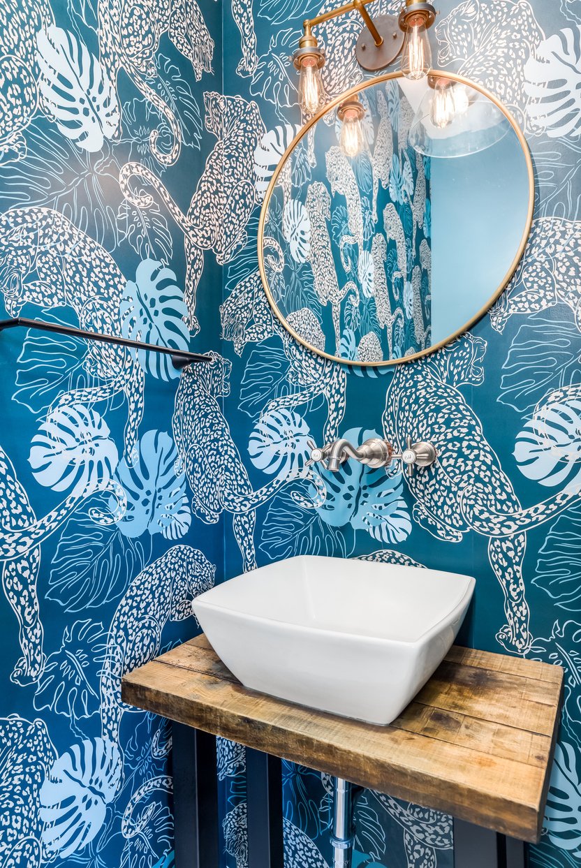 A bathroom with blue wallpaper.